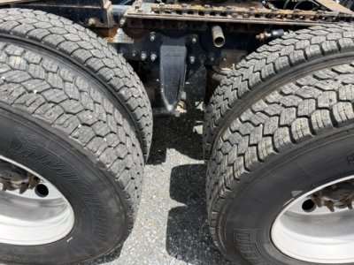 Freightliner Cascadia truck chassis showing dual rear wheels and suspension components.