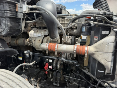 [Component] Engine bay view of a 2018 Freightliner Cascadia CA125DC showing engine, hoses, radiator, and wiring harnesses.