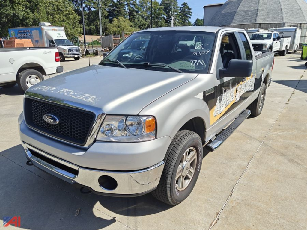 2007 Ford F-150 extended cab pickup truck, silver, front and passenger side view in a parking lot, 4x4, XL trim with running boards and graphic decal on side.