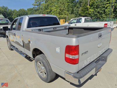 2007 Ford F-150 extended cab pickup truck rear-right view showing truck bed and tailgate, gray color, step bumper, and decals on side.