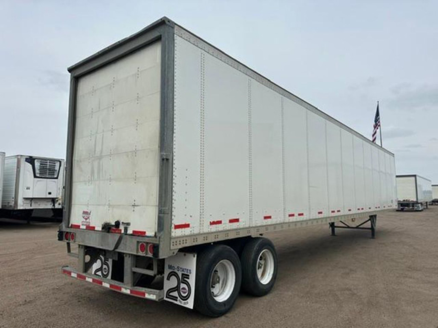 Trailer rear and side view showing a white 2016 Wabash van semi-trailer with dual rear axles and mud flaps, stock U90906, VIN 1JJV532D2GL908636.