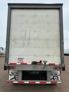 Rear view of a 2016 Wabash box trailer showing back doors and reflective tape. Visible text includes N/A on license areas and small labels at bottom right and left reading 'MId-STATE' and 'STATES'.