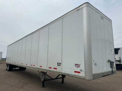 Trailer side view showing white Wabash van trailer with 53' mark and riveted panels, undercarriage and tandem wheels visible.