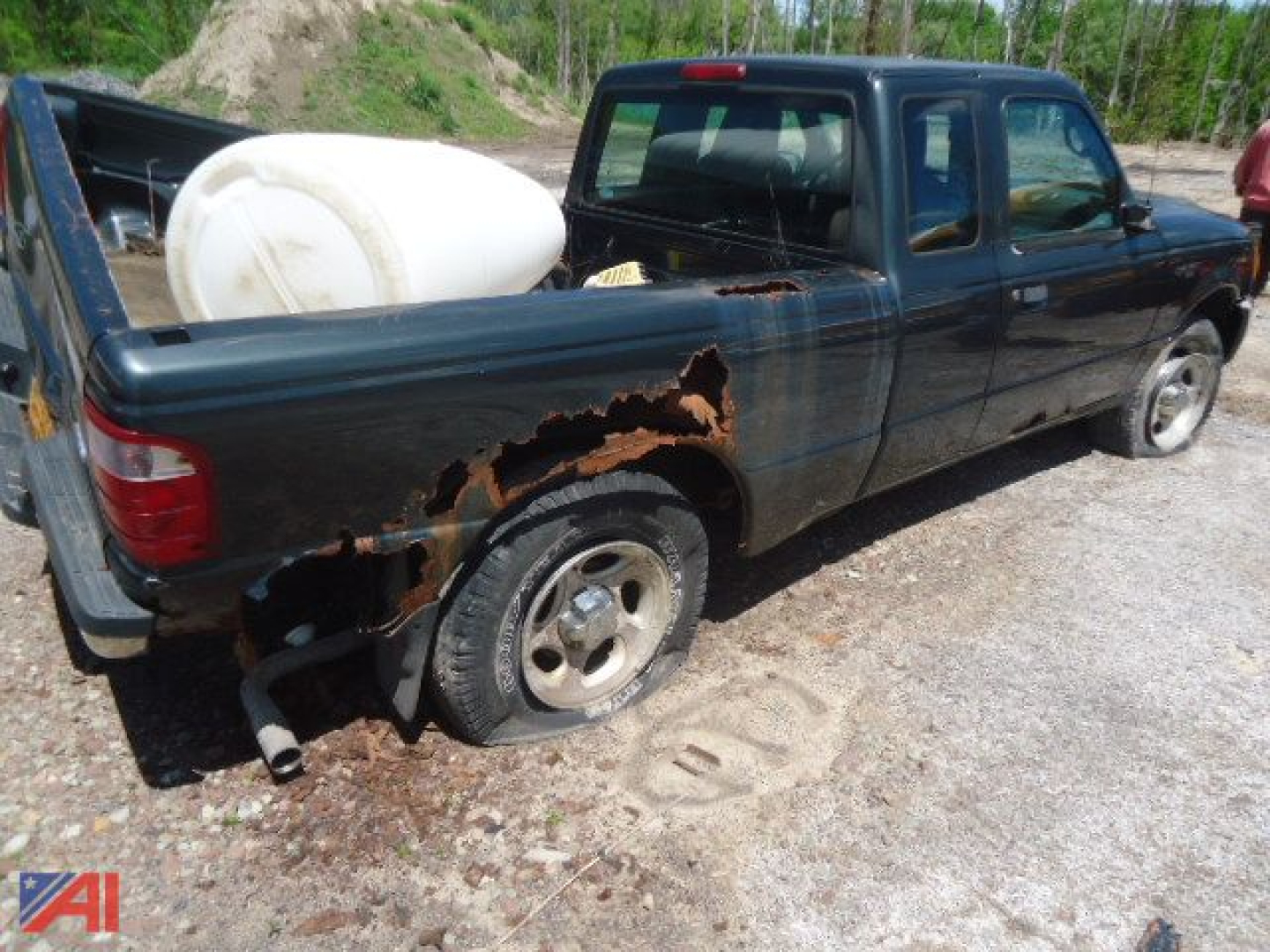 2005 Ford Ranger XLT pickup with damage on left rear quarter panel and fuel tank in truck bed.