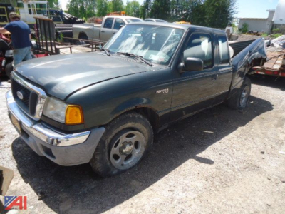 Ford Ranger XLT 2005 compact pickup truck 4x4 with extended cab view showing front-left and passenger side, gray body, chrome bumper, wheel arch, in a salvage yard.