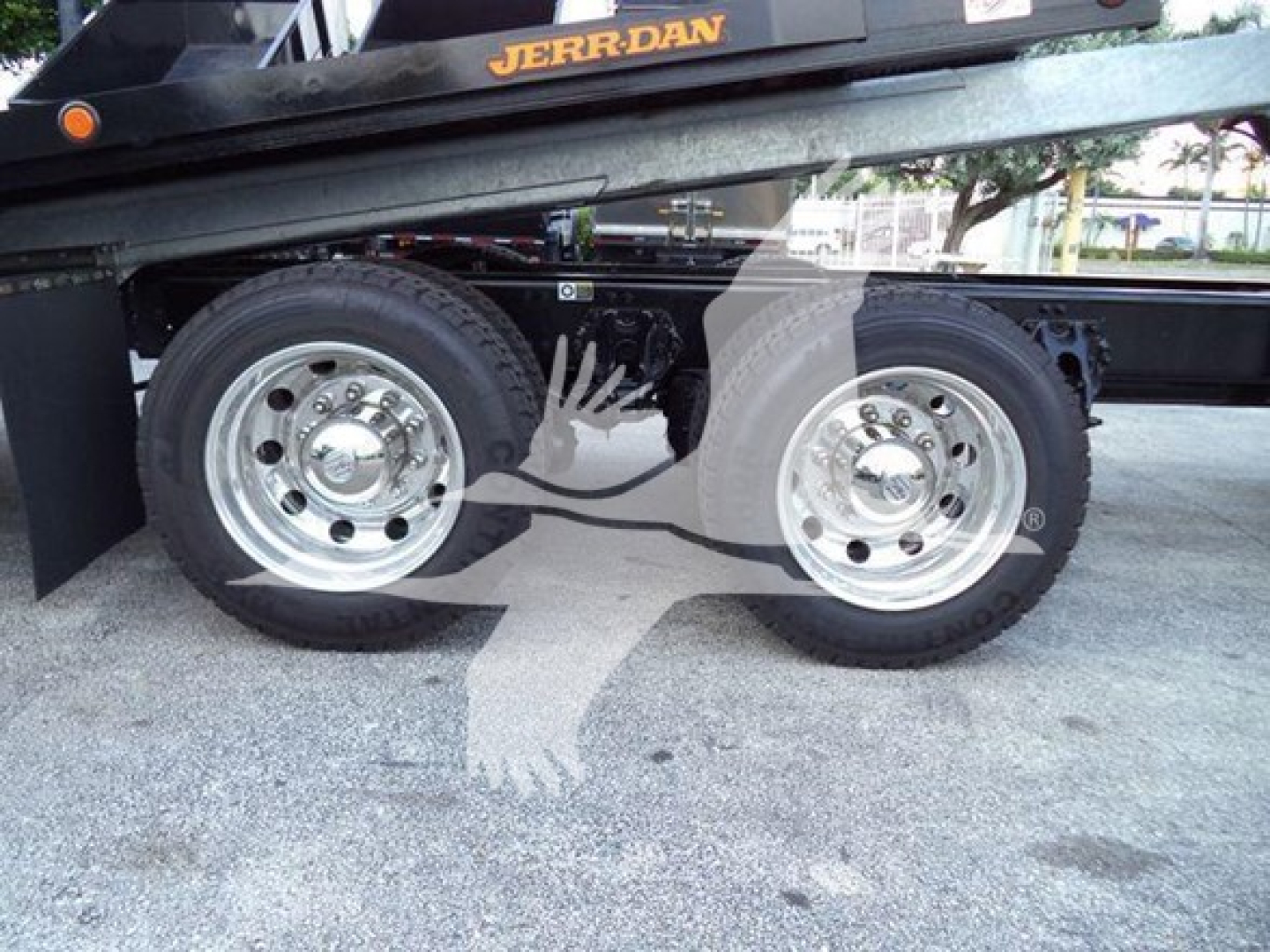 Kenworth T880 rollback truck dual rear axles with polished chrome wheels and black chassis.