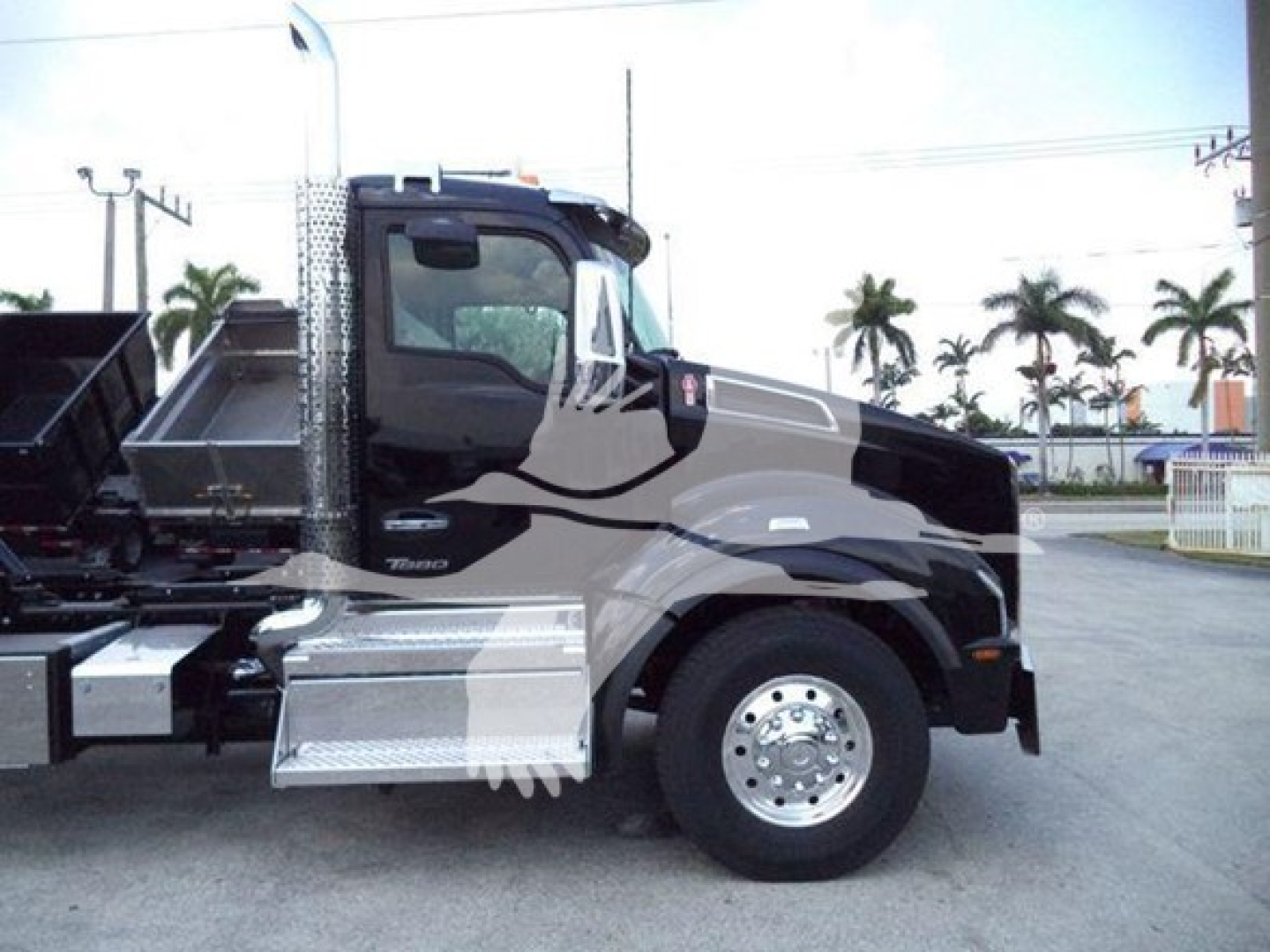 Kenworth T880 rollback truck with chrome steps and front wheel, side view showing cab and fuel tank area.