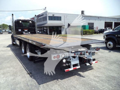 Kenworth T880 rollback truck flatbed trailer rear view showing hydraulic equipment and utility lights.