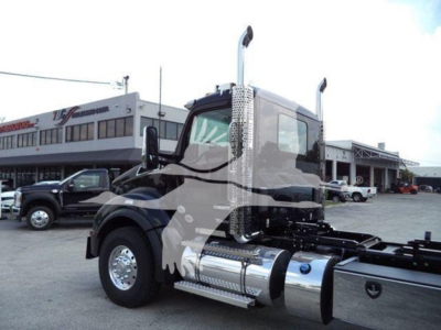 Kenworth T880 rollback truck cab and chassis with chrome fuel tanks and exhaust stacks, front left view, new vehicle in dealership lot.