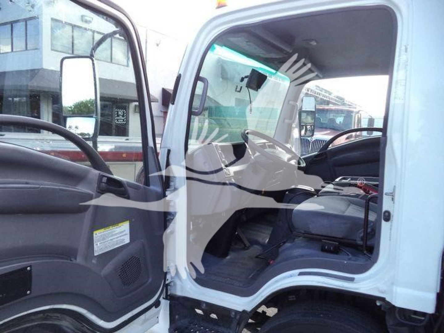 Isuzu NPRR cab interior visible through open door showing steering wheel and dashboard