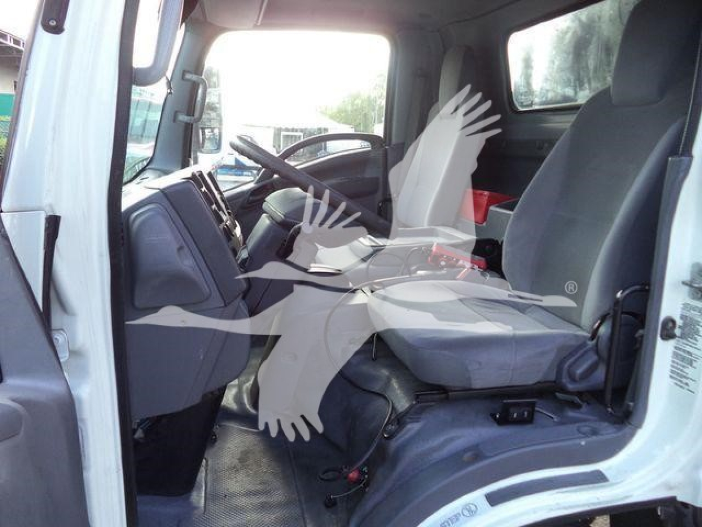 Isuzu NPR or similar cab interior showing driver and passenger seats, steering wheel, and dashboard