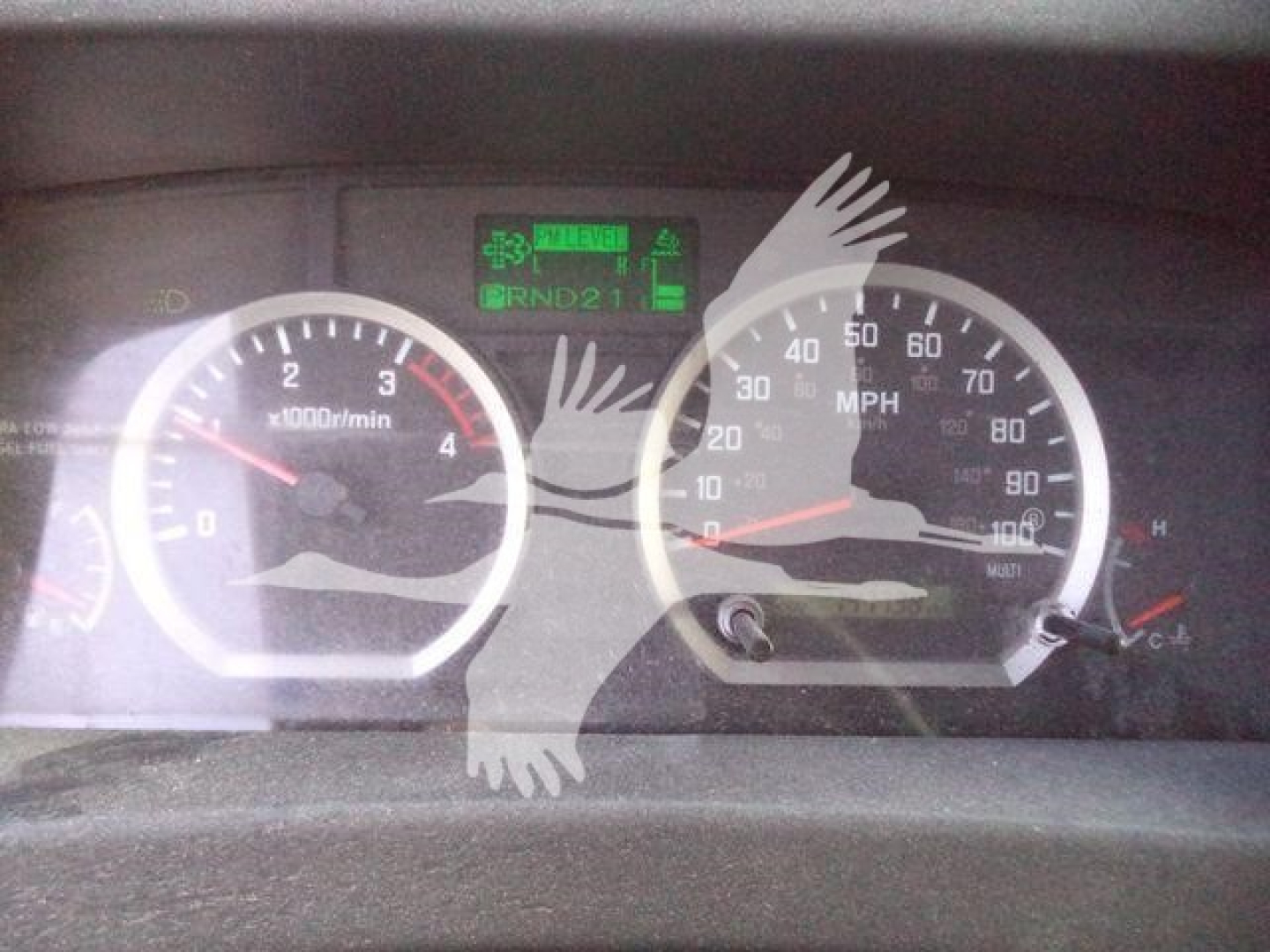 Isuzu NPRR dashboard showing tachometer and speedometer with central digital display and green indicators.