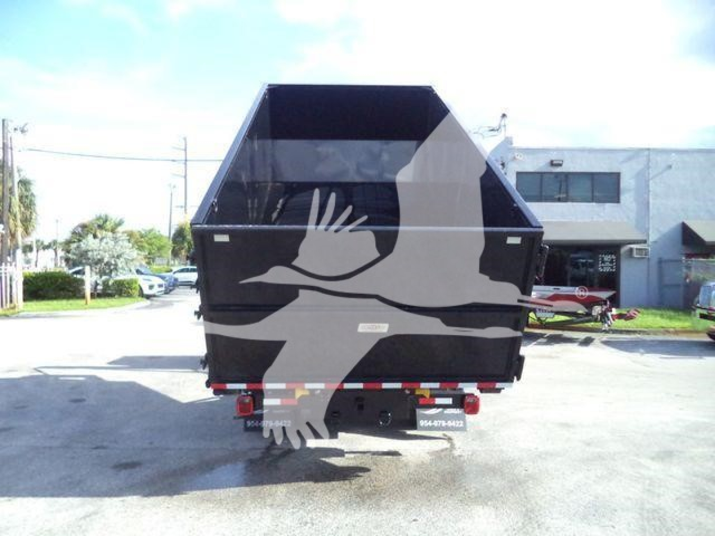 Isuzu NPRR/Nrr dump truck rear view showing open dump bed and bumper with reflective tape.