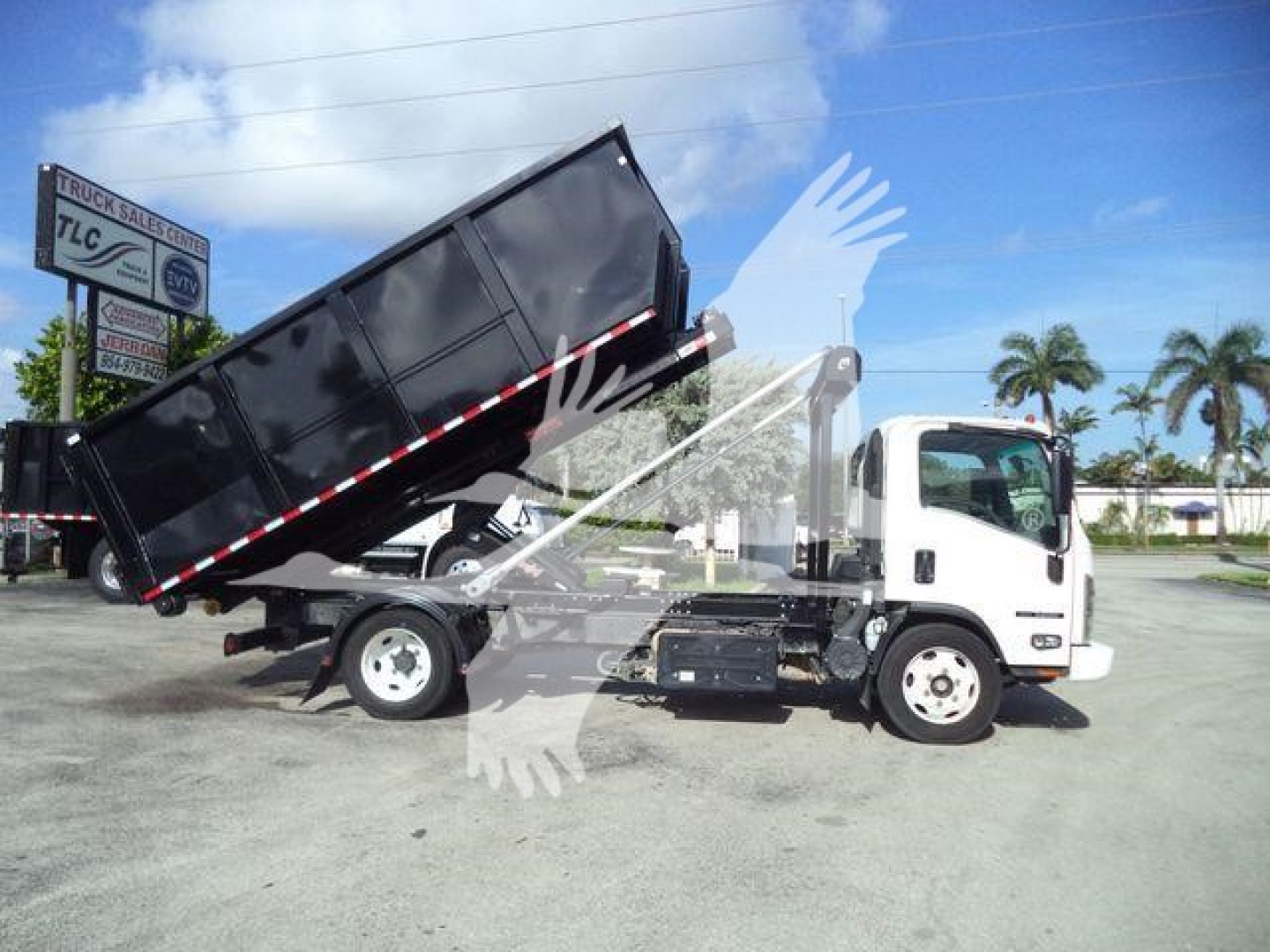 Isuzu NPR truck in service dump body lowered for display with raised tipping bed and hydraulic components visible