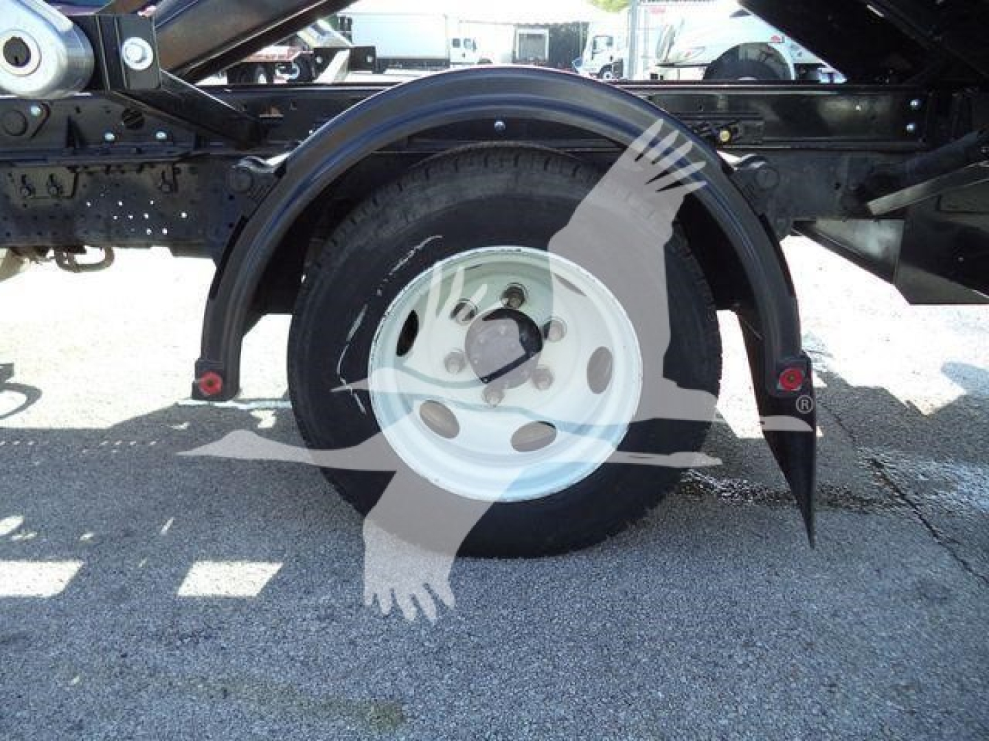 Isuzu NPRR truck rear wheel assembly showing wheel, fender, and frame components undercarriage.