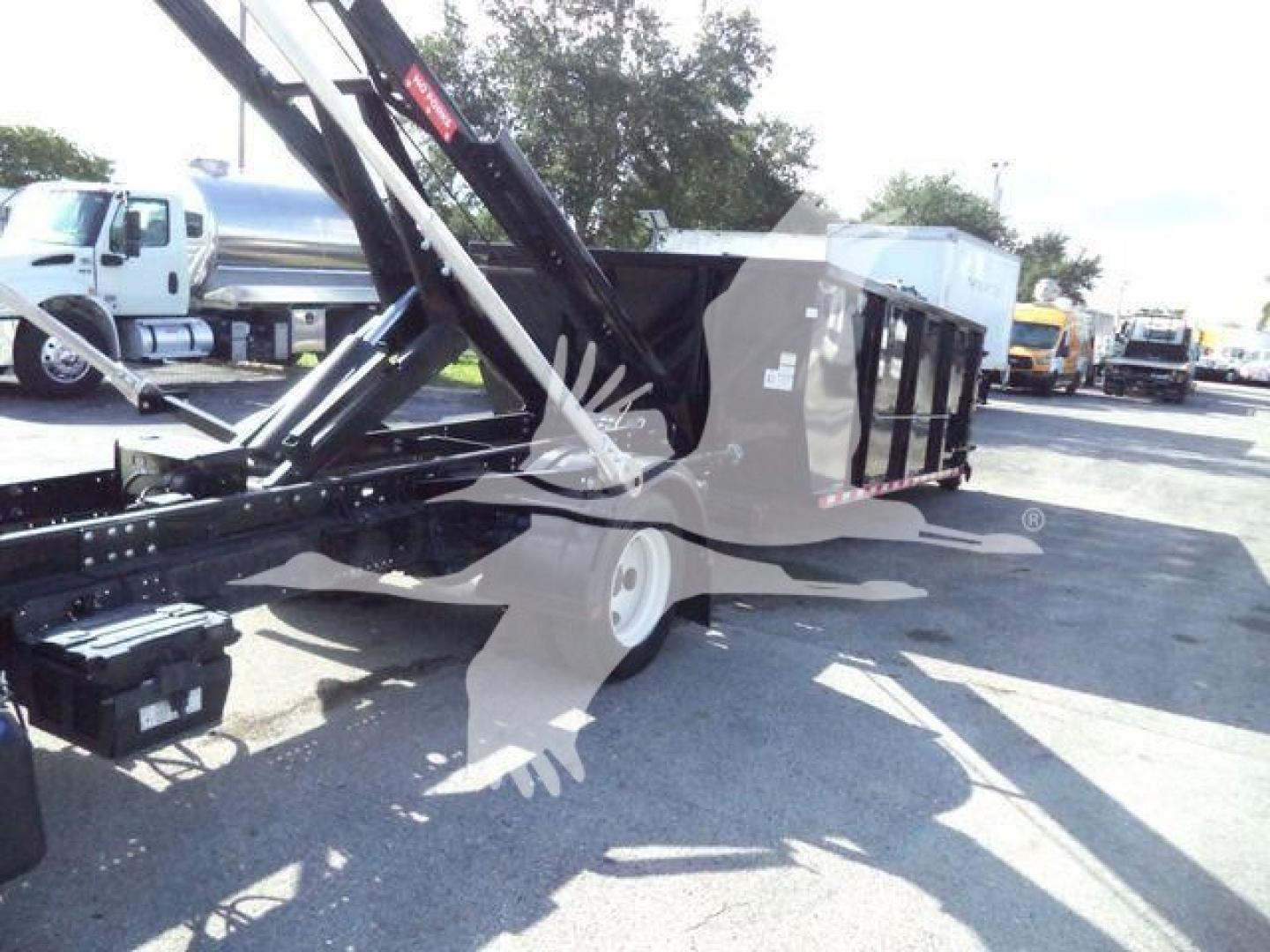 Isuzu NRR roll-off truck body with hydraulic crane arm visible, side view showing dumpster bed and support frame.