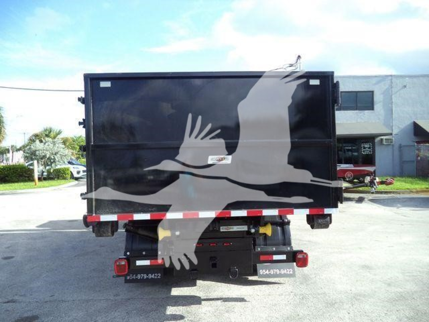 Isuzu NPRR roll-off truck cargo area rear view with graphic of a bird on black container.