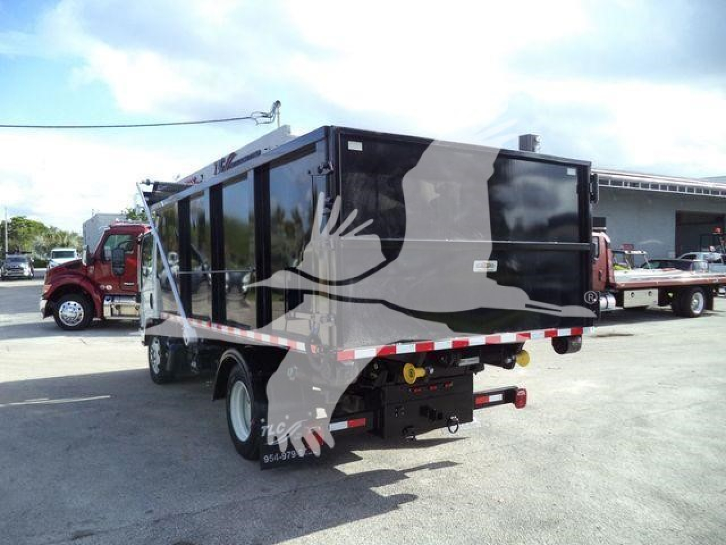 Isuzu NPR/NRR rolloff truck rear view showing cargo bed and rear bumper with lights.