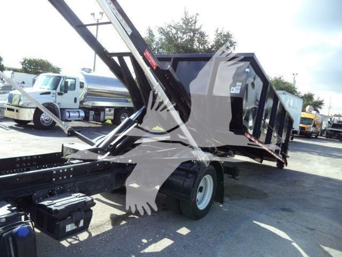 Isuzu NPR/NRR roll-off truck with dump bed tilted, showing side and rear; no legible engine or label text visible.