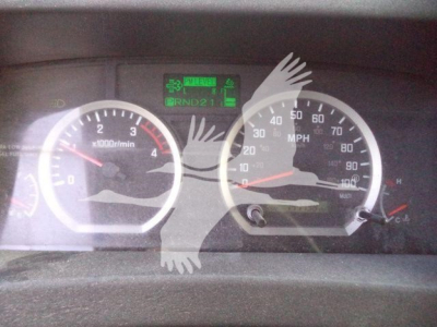 Isuzu NPRR dashboard showing tachometer and speedometer with central digital display and green indicators.