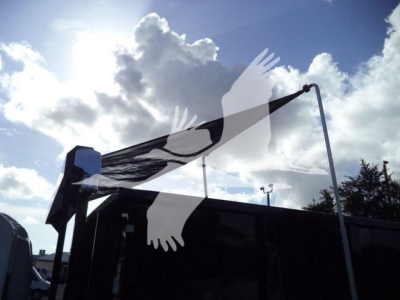 Isuzu NRR roll-off truck side view with a black tarp and frame in the bed; no legible model text visible.