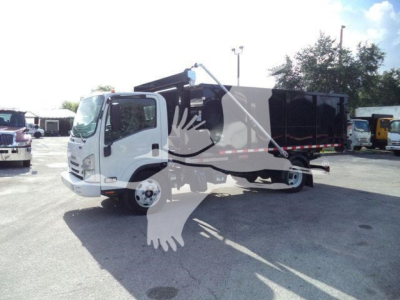 Isuzu NPR/NRR dump truck in service showing cab and dumping bed with hydraulic lift in a lot.