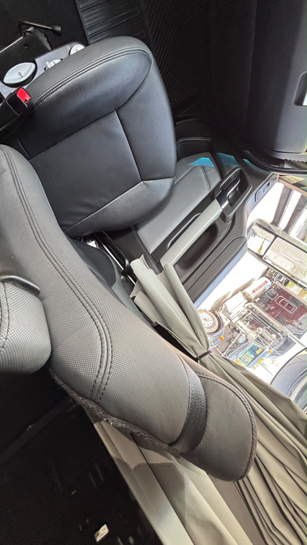 Cab interior of a Kenworth T680 showing front seats and center console in view