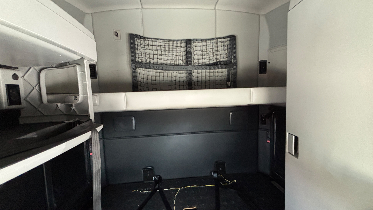 Kenworth T680 sleeper cab interior showing bunk compartments and storage area.