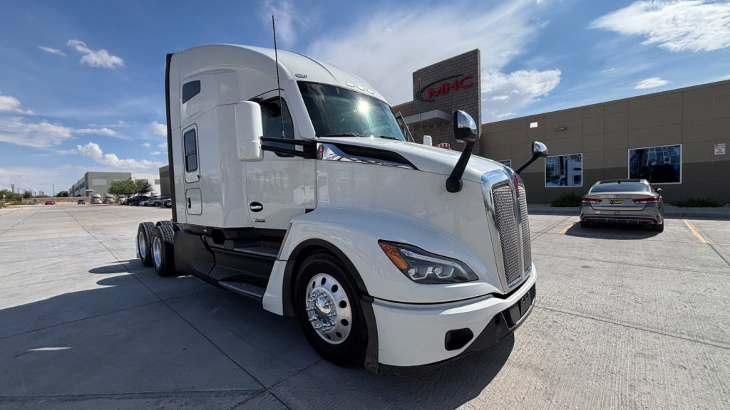 Kenworth T680 sleeper cab tractor in a parking lot, front-left view, white color, no visible text on exhaust or mirrors.