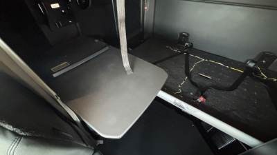 Kenworth T680 cabin interior showing a fold-out sleeper tray/table with surrounding floor and seat rails visible.