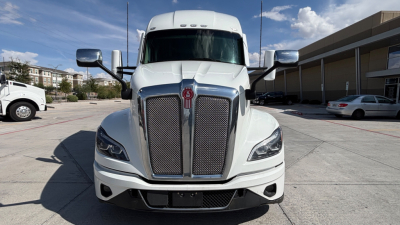 Kenworth T680 truck front view showing bold grille and headlights under clear sky.