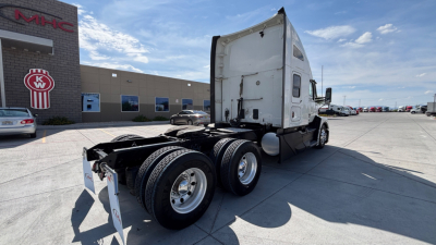 Kenworth T680 tractor with sleeper cab viewed from rear-side, showing dual rear axles and fifth-wheel area.