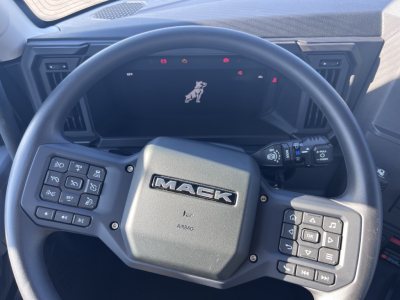 Mack AN64T truck interior showing steering wheel with Mack logo and control panels on both sides of the wheel.