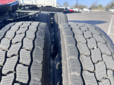 Twin rear truck tires on a Mack AN64T tractor showing tread pattern and wheel wells.
