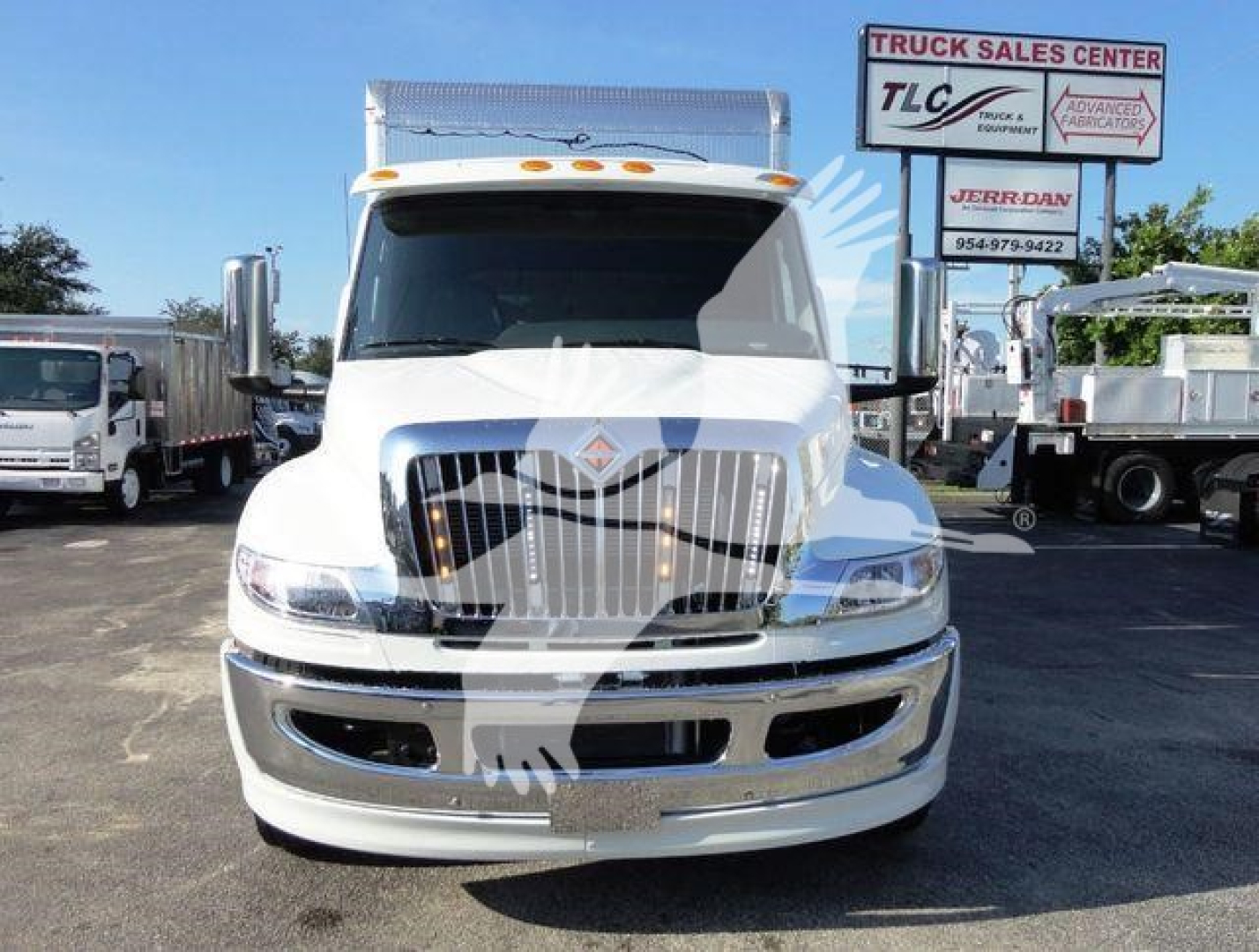 Front view of a white 2022 International MV truck in a dealership lot with chrome grille and bumper, stock number J93674.