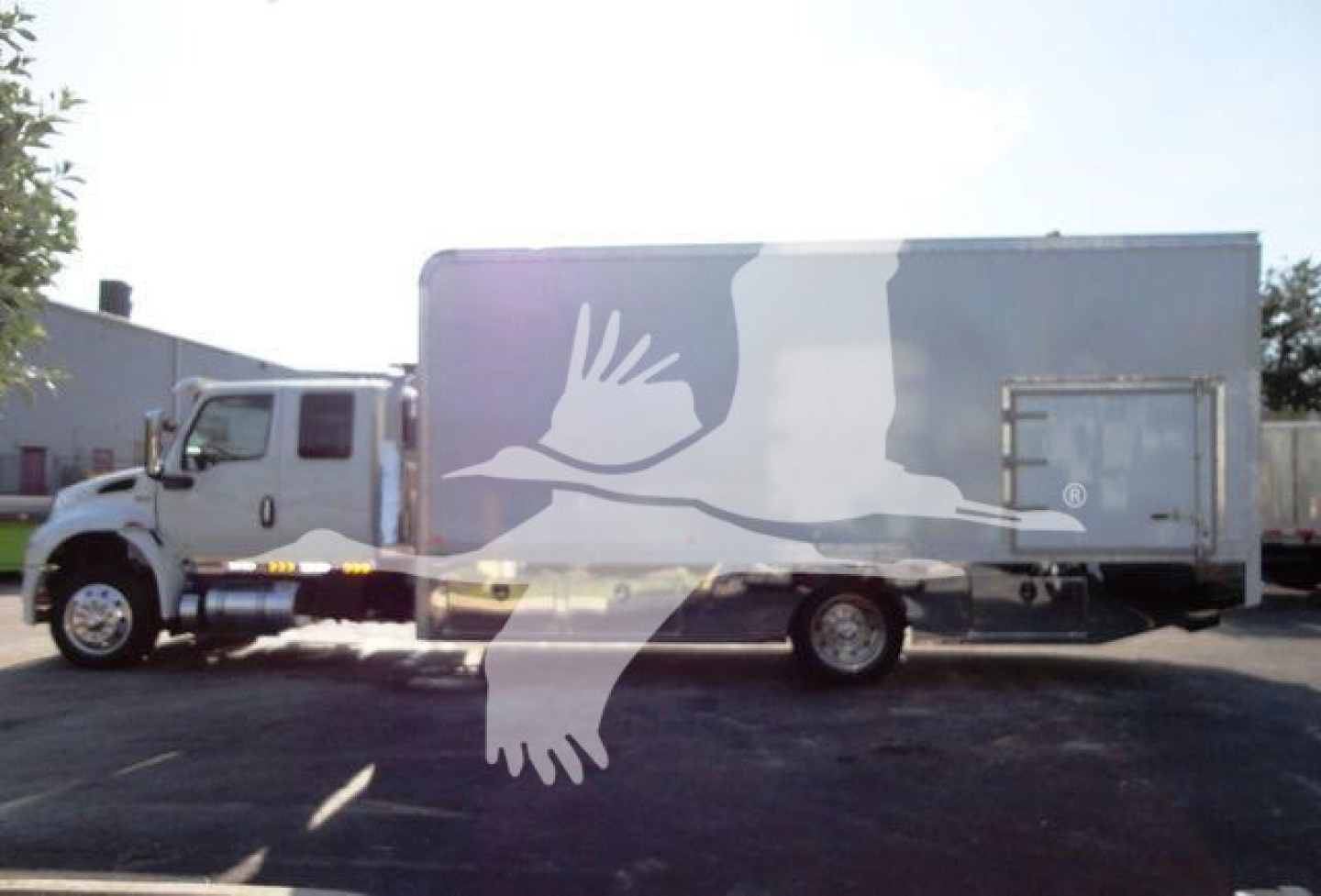 Truck side silhouette with wrapped transport box showing no legible labels; image of a 2022 International MV rollback truck.