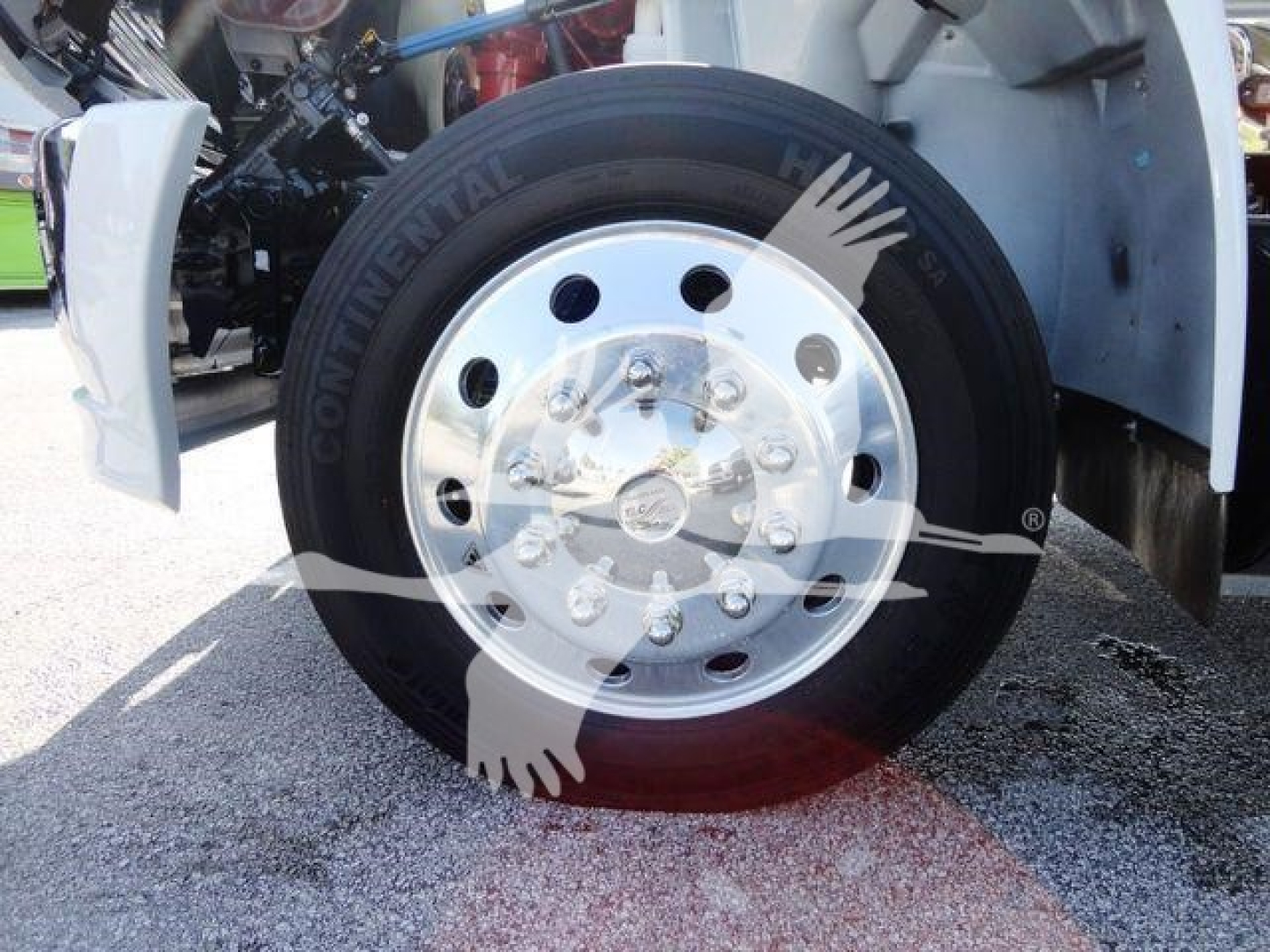 Continental tire on a 2022 International MV truck front wheel with shiny silver rim and hub, part of rollback equipment.