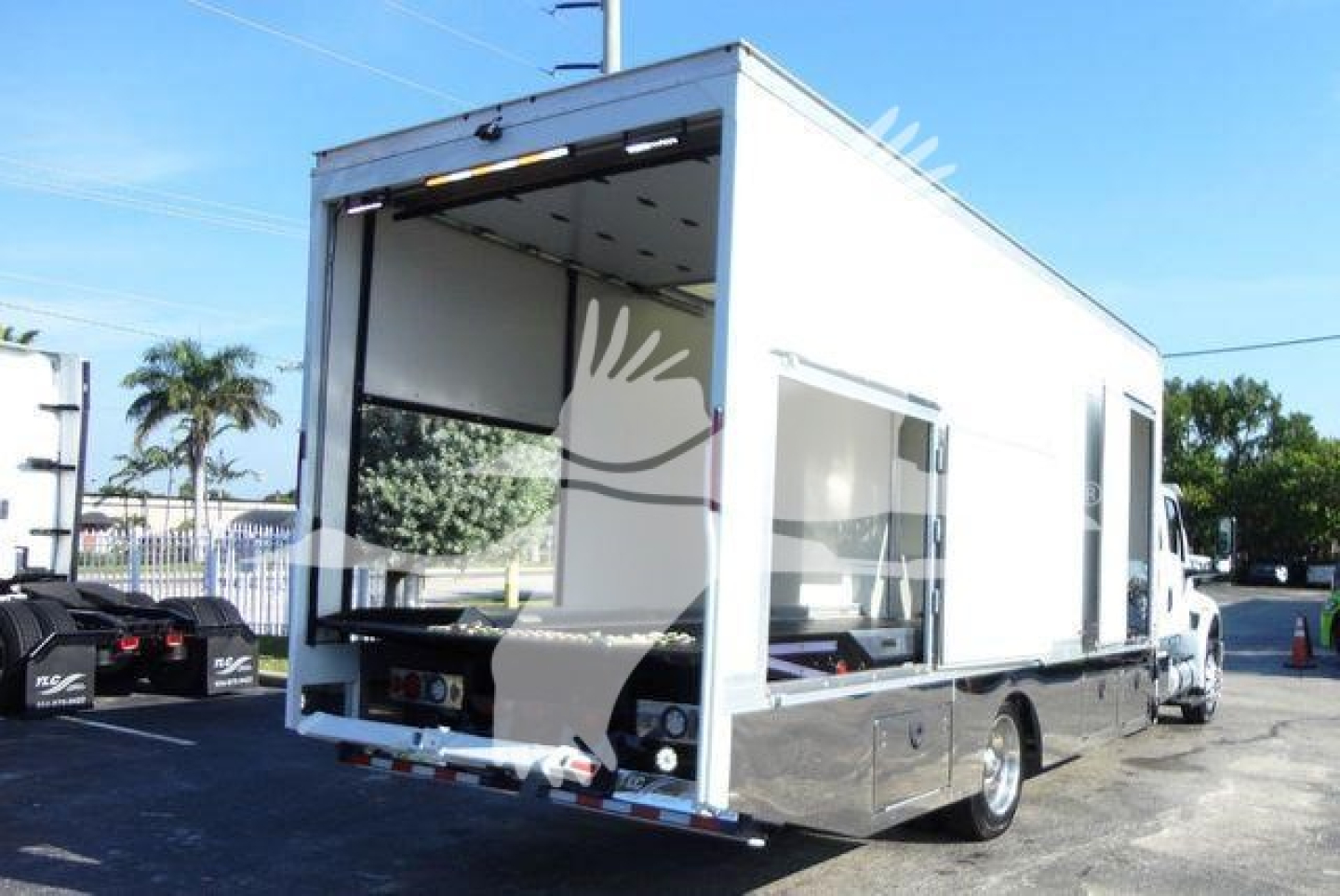 Truck box truck with rear open cargo area and side entrance, MV model, rolling stock in lot.