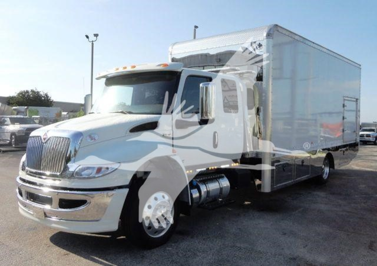 International MV box truck front-left view with cab and large cargo box; stock number J93674; rollback category; new truck.