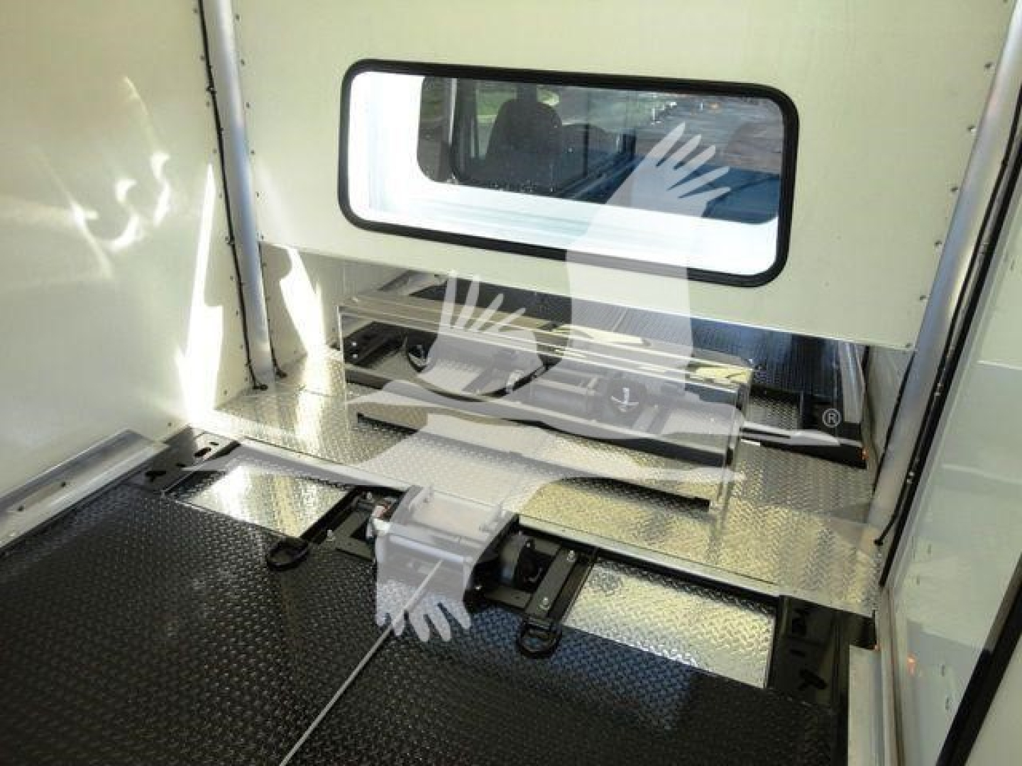 Interior of a 2022 International MV rollback truck cargo area showing aluminum floor with cross tread, side wall with window, load restraint tracks, and a metal step mechanism.