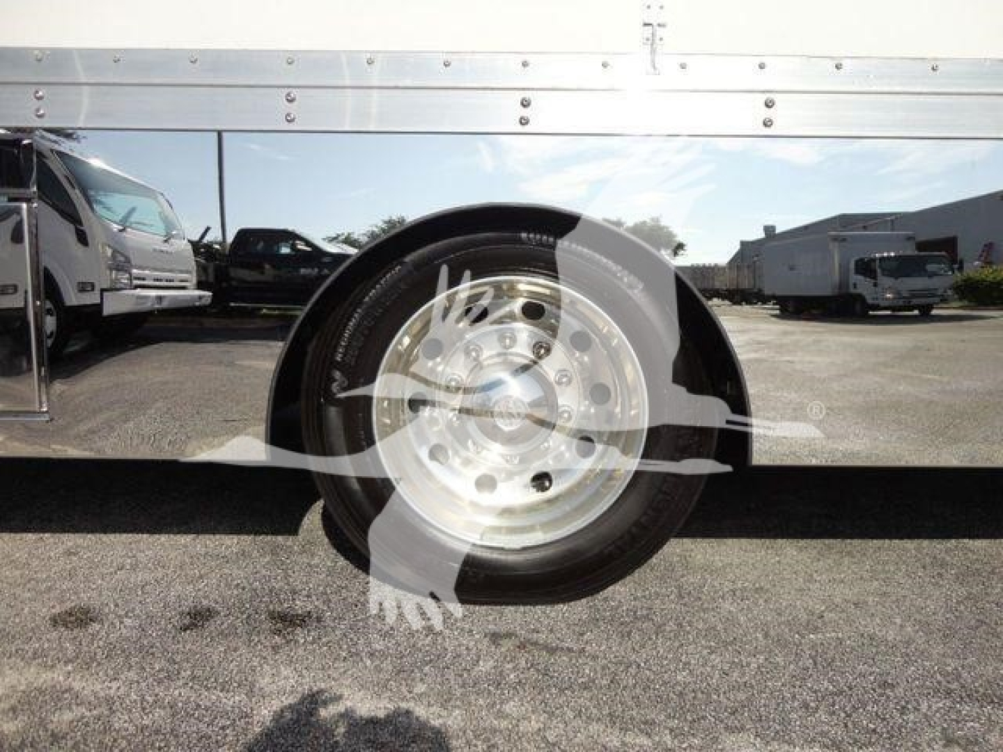 Truck wheel and fender area with metal side panel; circular emblem overlay on wheel hub