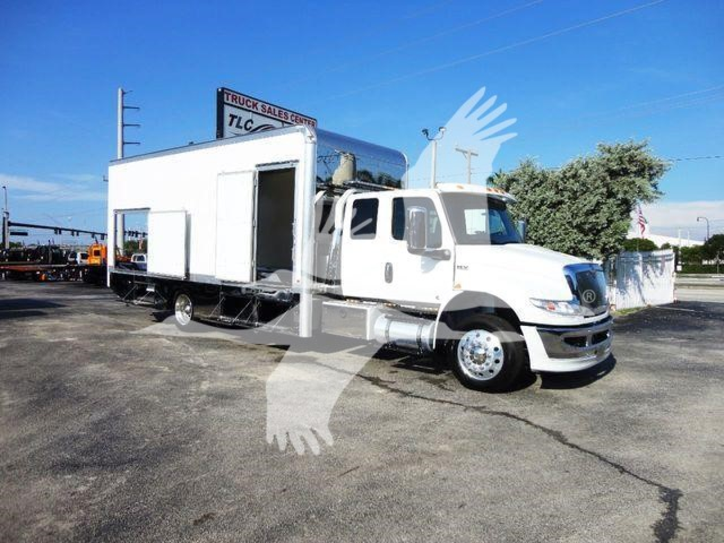 Truck in service bay showing 2022 International MV rollback truck with a large white living quarters module mounted on a truck chassis.