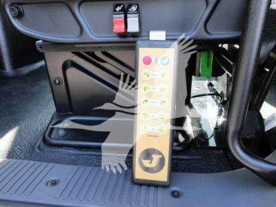 Panel with red and black toggle switches above a control module, and a vertical yellow button panel with numbered circles in a truck cab interior.
