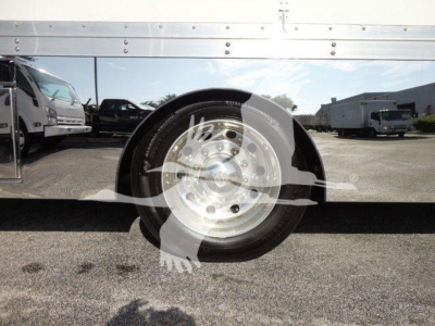 Truck wheel and fender area with metal side panel; circular emblem overlay on wheel hub