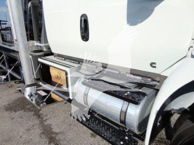 Truck cab area showing side fuel tank and steps with metal railings and storage compartments.