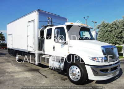 Truck cab and large box body of a 2022 International MV rollback truck showing white exterior and chrome grille.