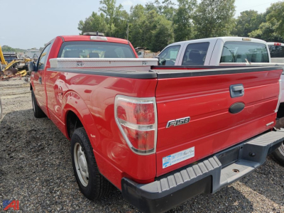 Ford F-150 pickup rear view showing tailgate with F-150 badge and truck bed in red color