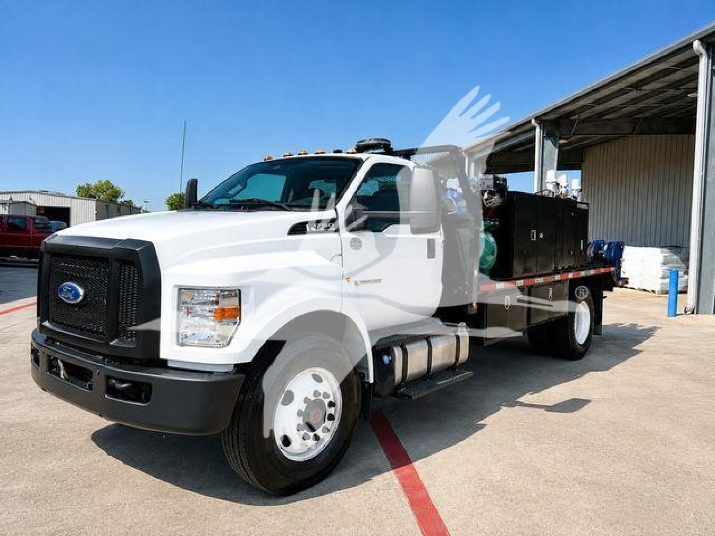 Ford F-750 utility truck in-service view showing front grille, cab, and flatbed with equipment container.