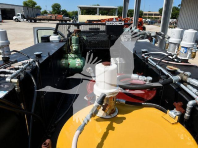 Truck engine bay showing large yellow fuel tank, various hoses, and components in a Ford F750 XL SD.