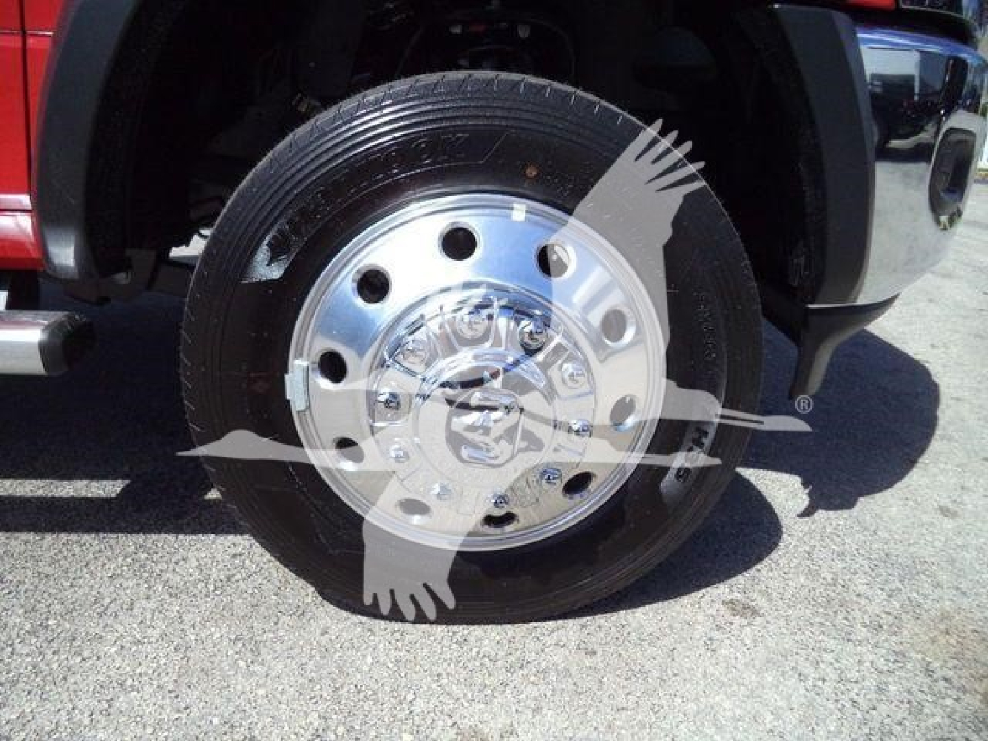 Wheel and tire assembly of a 2024 Ram 5500 SLT with polished aluminum hubcap and tire resting on pavement.